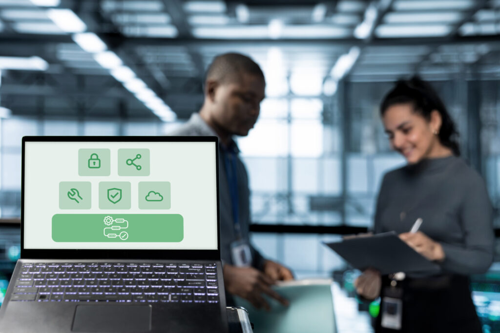 Brauchen Sie wirklich Verinice, HiScout & Co.? – So funktioniert ein ISMS mit Jira und Confluence 12 IT Fachkräfte arbeiten im Hintergrund während im Vordergrund auf einem Laptop Prozessberatung als Fundament für andere Systeme angezeigt wird.